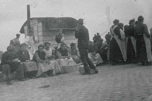 Vissersvrouwen en vishandelaars voor de houten loods die dienst deed als eerste vismijngebouwtje, 1909